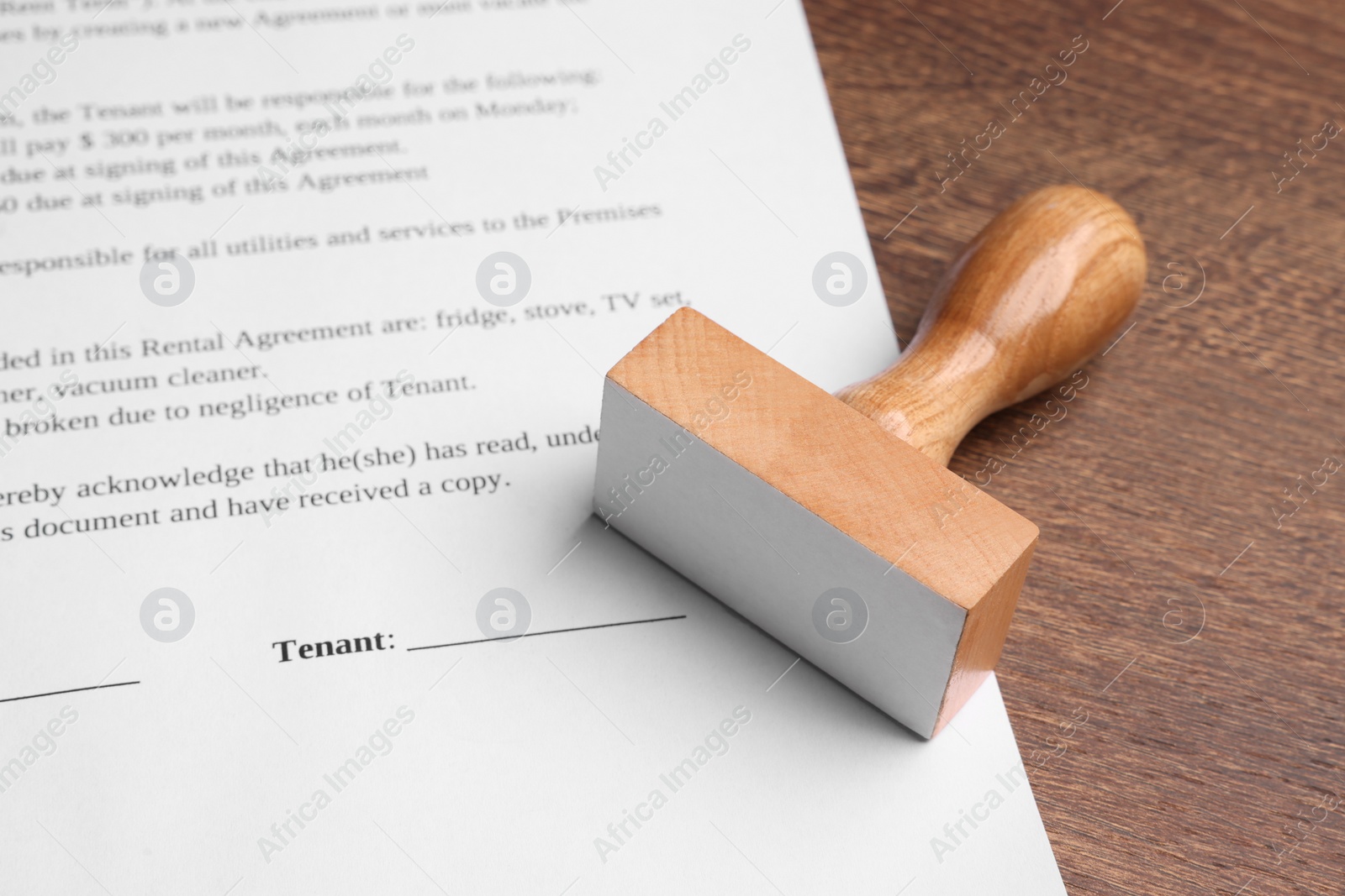 Photo of One stamp tool and document on wooden table, closeup