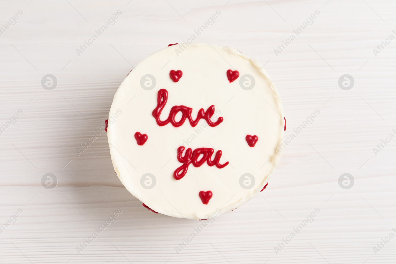 Photo of Bento cake with text Love You on white wooden table, top view. St. Valentine's day surprise