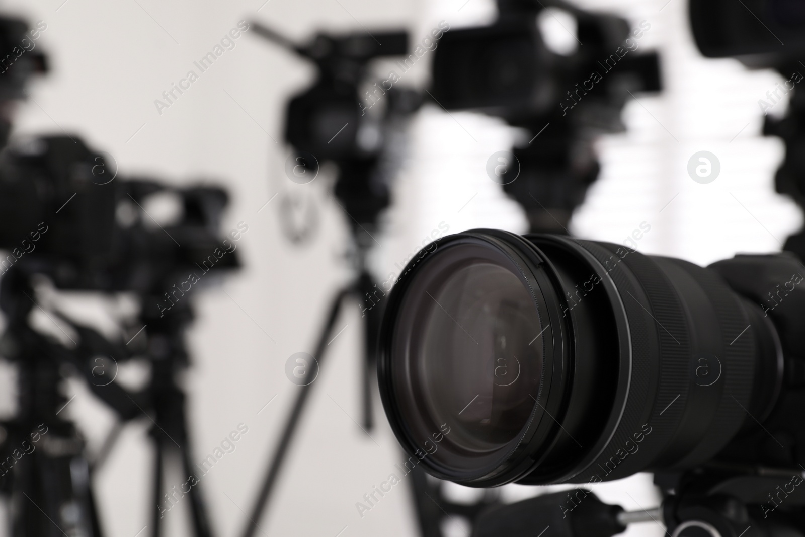 Photo of Modern video camera indoors, focus on lens. Professional media equipment for broadcasting event