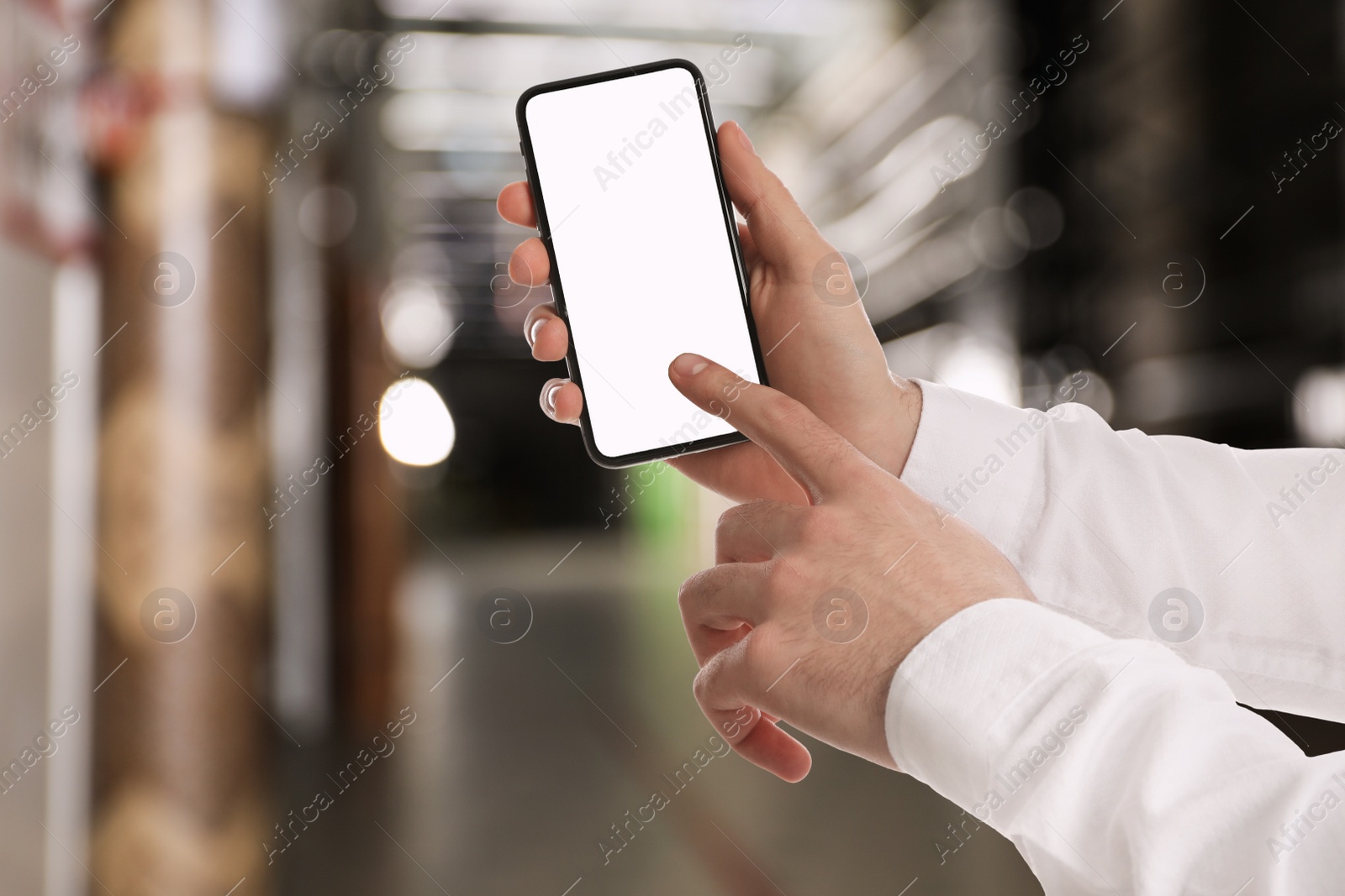 Image of Wholesale trading. Man using WMS app on smartphone at warehouse, closeup 