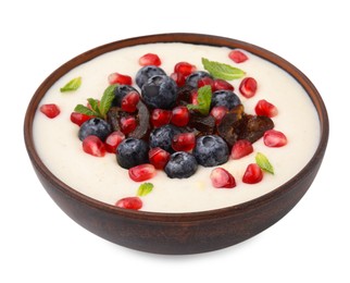 Photo of Delicious semolina pudding with blueberries, pomegranate, dates and mint in bowl isolated on white
