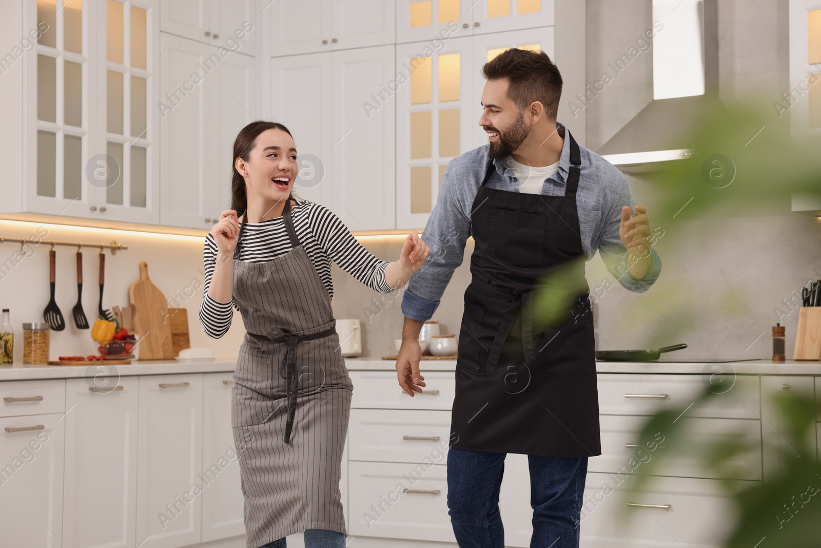 Photo of Happy lovely couple dancing together in kitchen