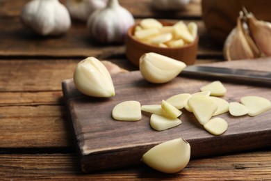 Photo of Fresh chopped garlic on wooden board, closeup. Organic product