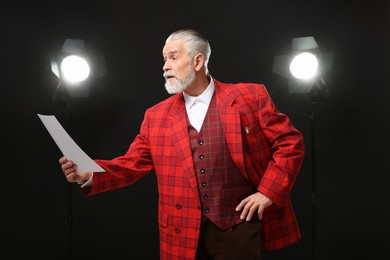 Photo of Senior actor with script performing on stage