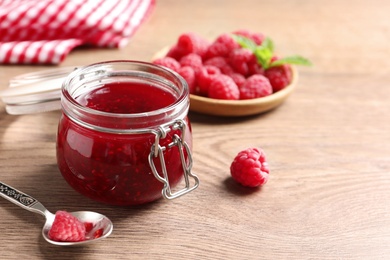 Image of Sweet raspberry jam and fresh berries on wooden table