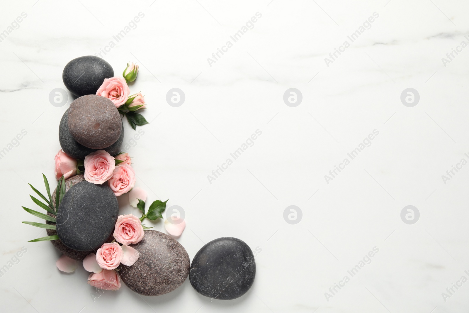 Photo of Flat lay composition with spa stones and roses on white marble table. Space for text