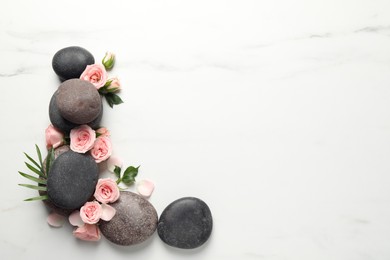 Flat lay composition with spa stones and roses on white marble table. Space for text