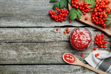 Delicious rowan jam and berries on wooden table, flat lay. Space for text