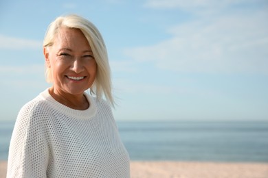 Beautiful mature woman on sea beach in summer