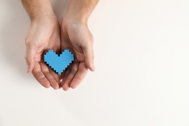 Man holding decorative heart on white background, top view with space for text