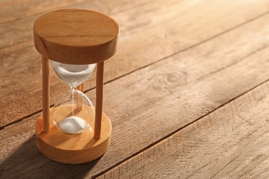 Hourglass with flowing sand on table. Time management