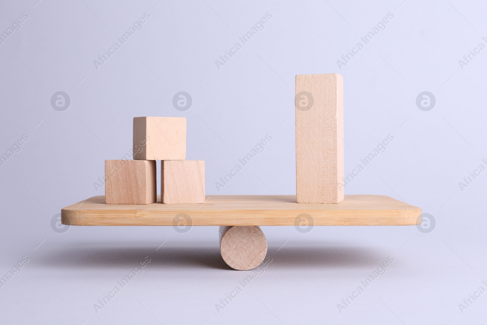 Photo of Equality concept. Seesaw scale with wooden blocks on light background