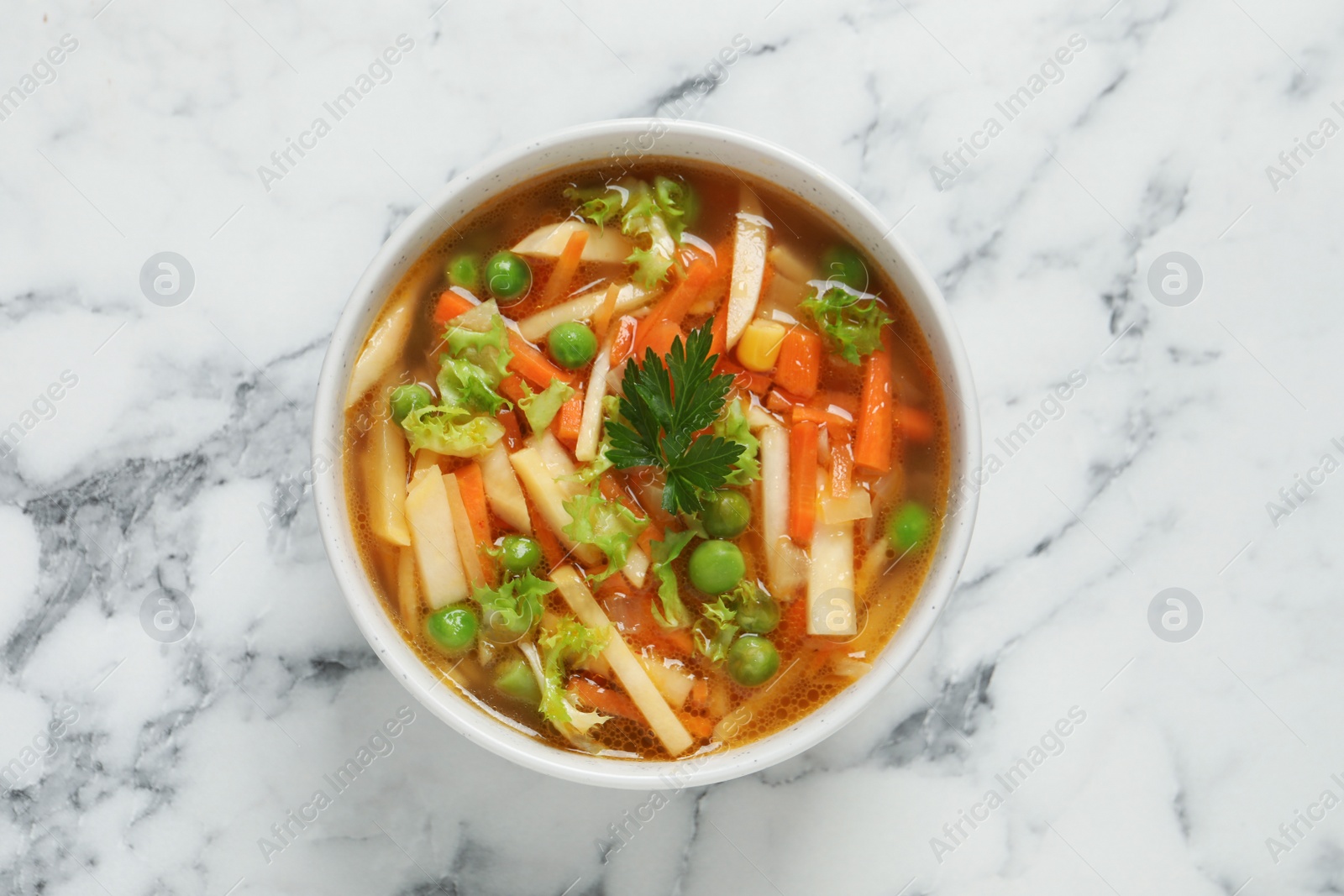 Photo of Bowl of delicious turnip soup on white marble table, top view