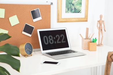 Stylish workplace with laptop on table in room