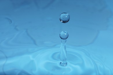 Photo of Splash of blue water with drop, macro view