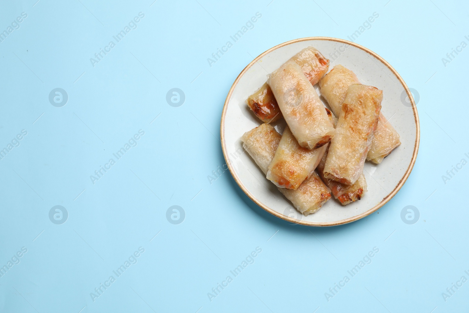 Photo of Fried spring rolls on light blue table, top view. Space for text