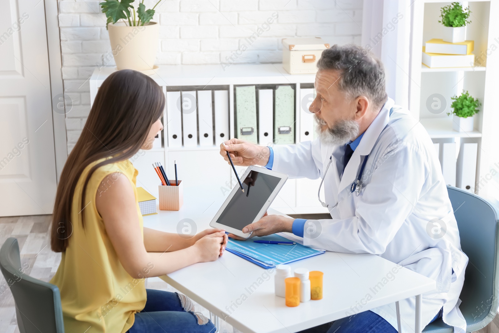 Photo of Mature doctor consulting patient in clinic