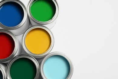 Photo of Open paint cans on white background, top view. Space for text