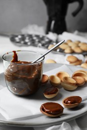 Photo of Delicious walnut shaped cookies with condensed milk on plate, closeup