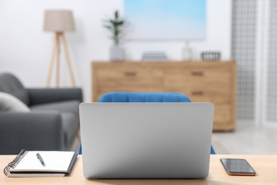 Photo of Home workspace. Laptop, smartphone and stationery on wooden desk indoors