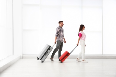 Young couple with suitcases in airport