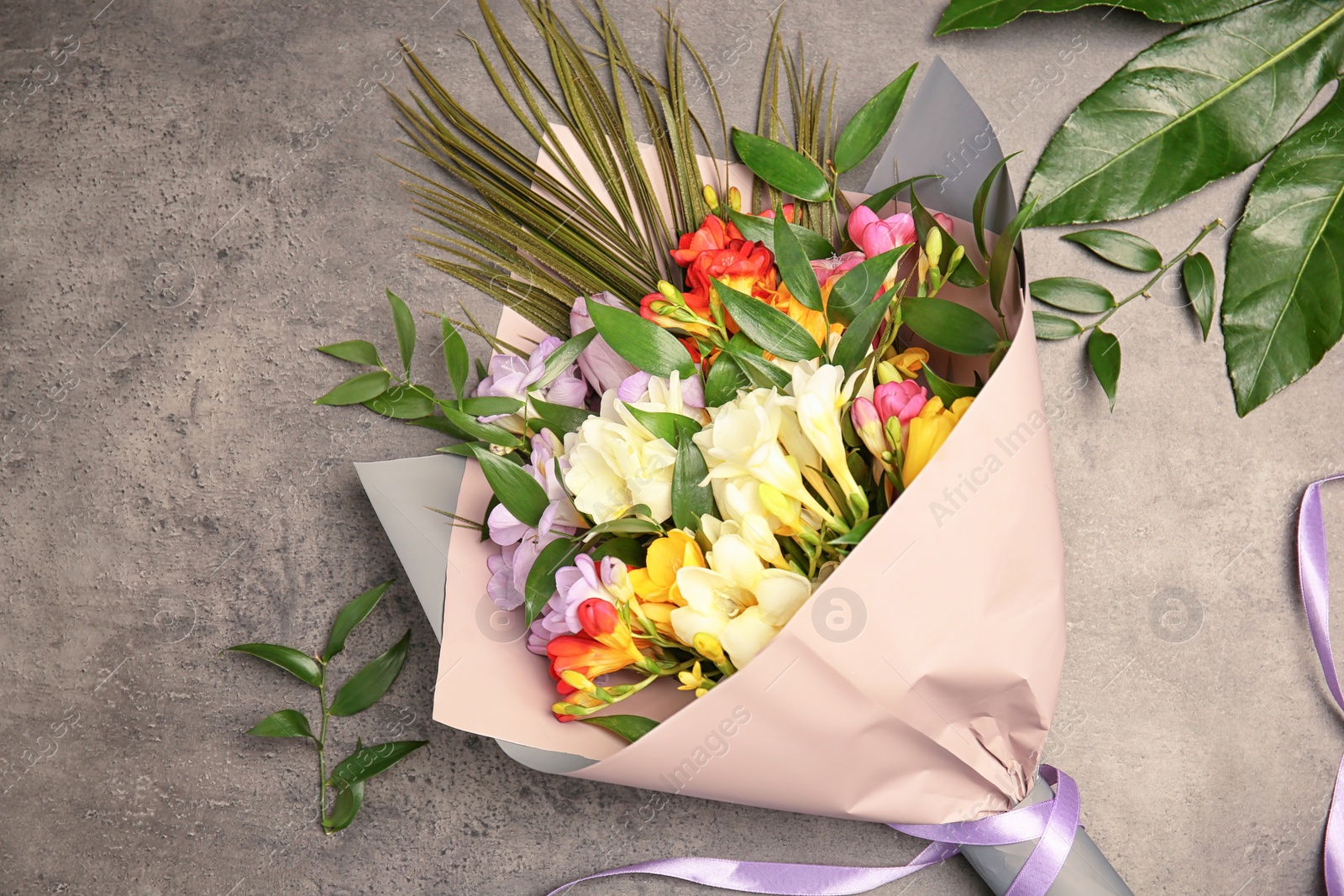 Beautiful bouquet of freesia flowers on grey background Photo of Beautiful bouquet of freesia flowers on grey background