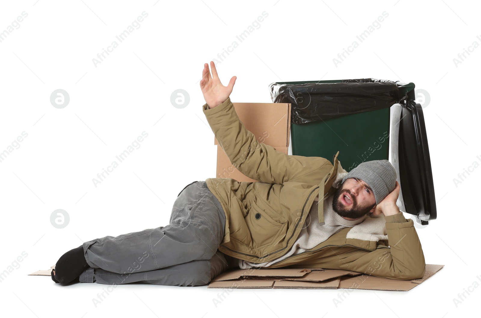 Photo of Poor homeless man lying near trash bin isolated on white