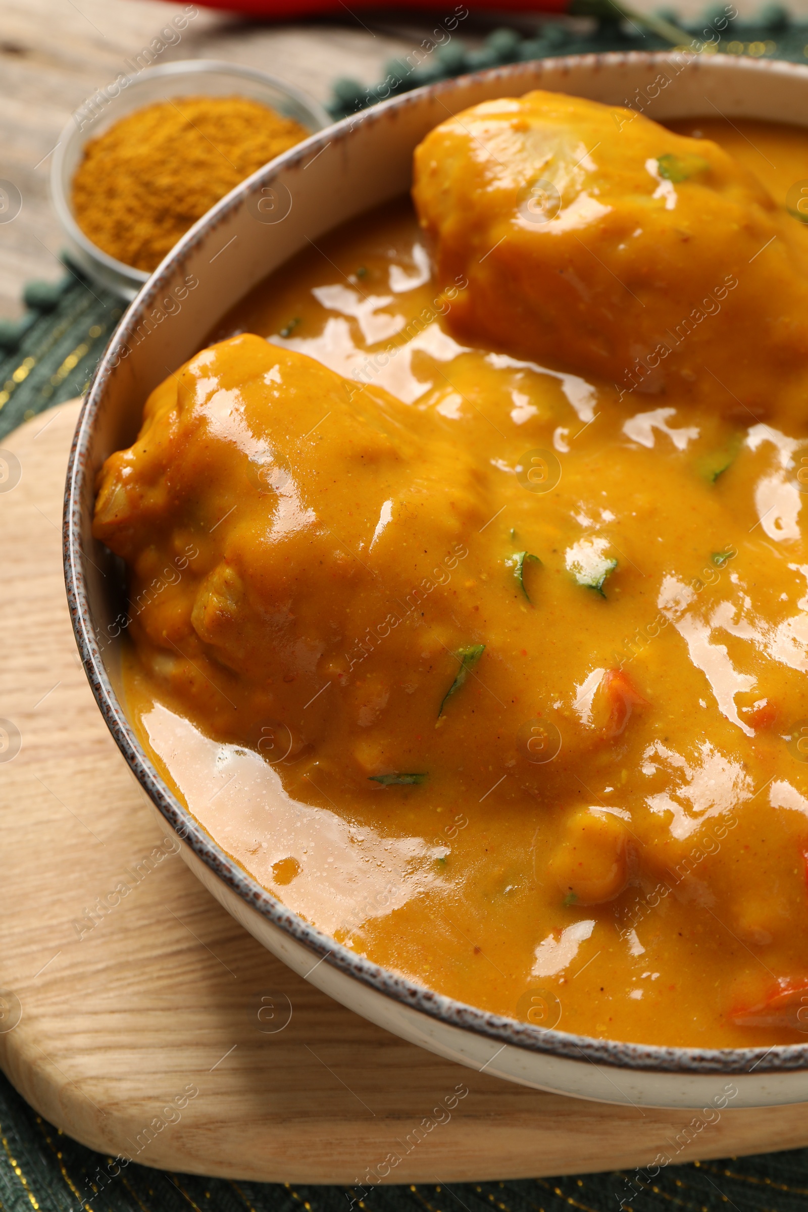 Photo of Tasty chicken curry and spice on table