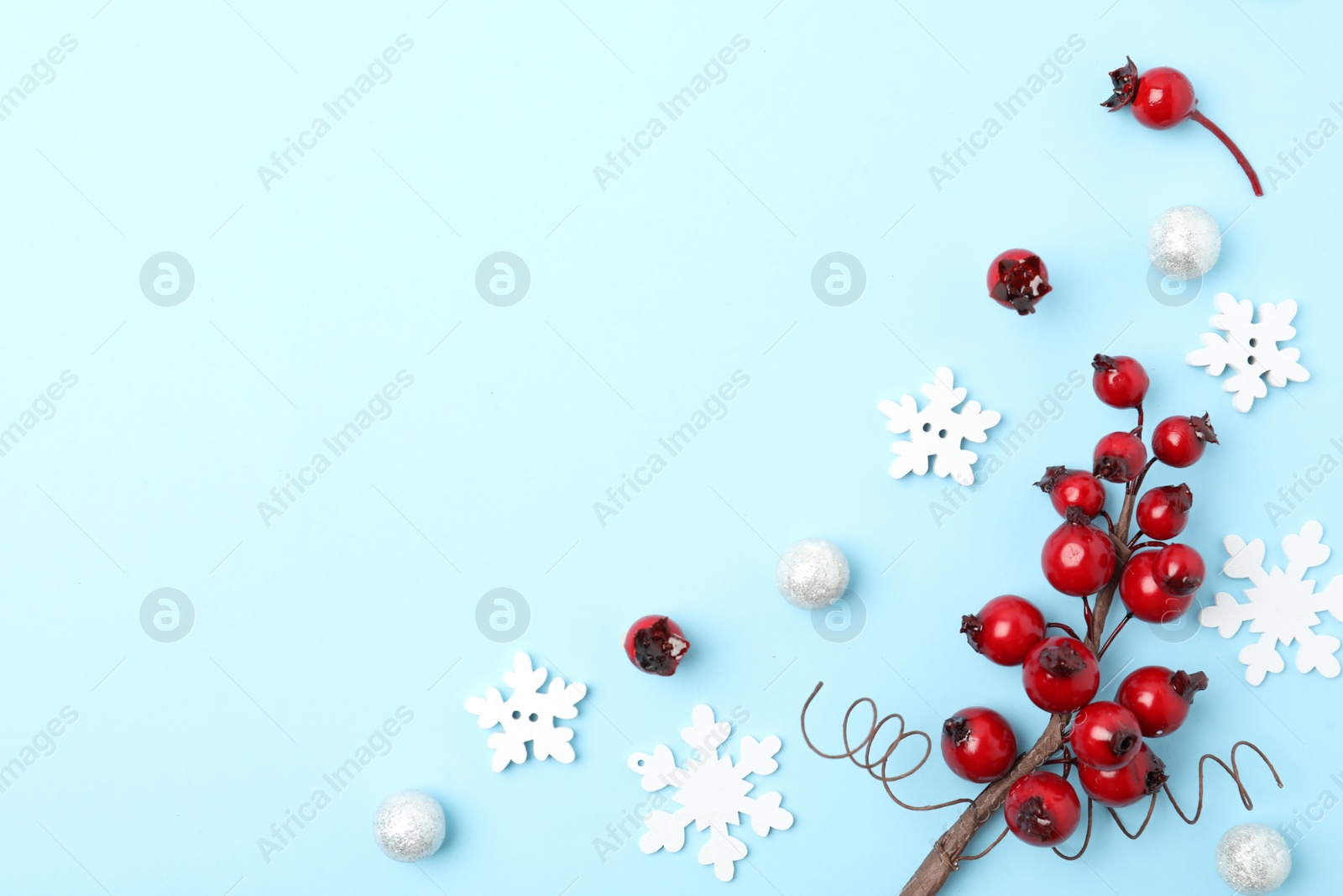 Photo of Winter composition with decorative branches on light blue background, flat lay. Space for text