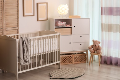 Modern room interior with crib and wooden crates under cupboard. Eco style