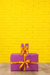 Photo of Gift boxes near yellow brick wall. Space for text