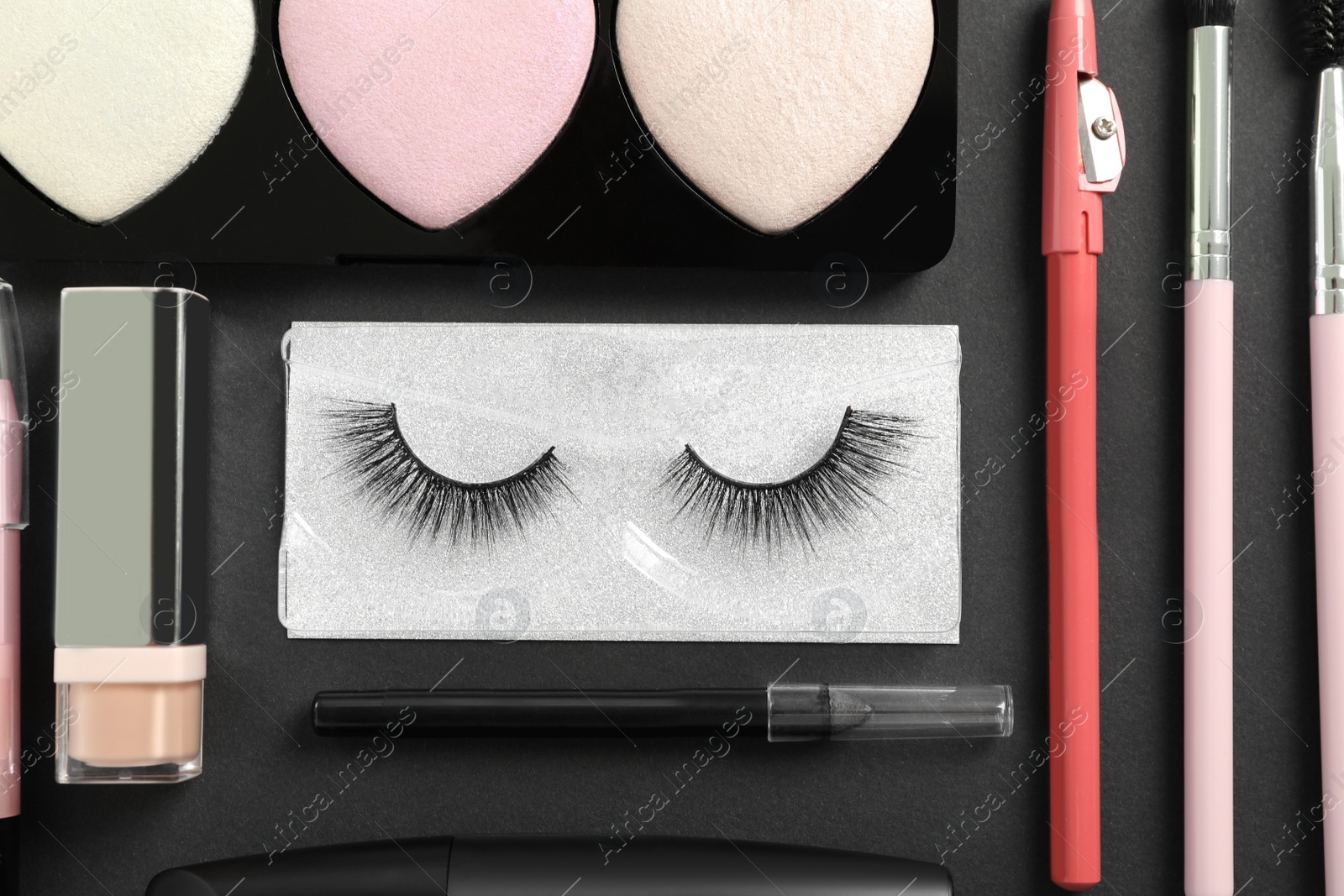 Photo of Set of makeup products on dark background, flat lay