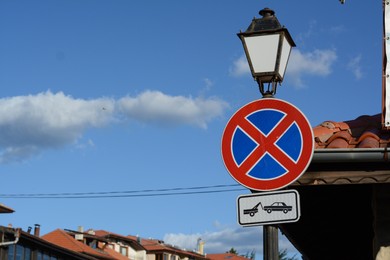 Traffic sign No Stopping on streetlight against blue sky