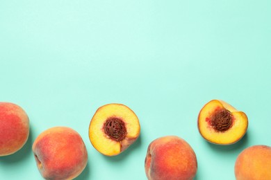 Photo of Cut and whole fresh ripe peaches on light blue background, flat lay. Space for text