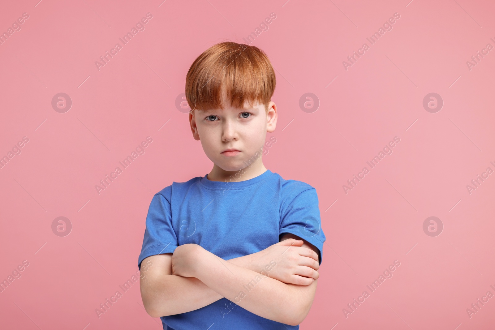 Photo of Portrait of sad little boy on pink background