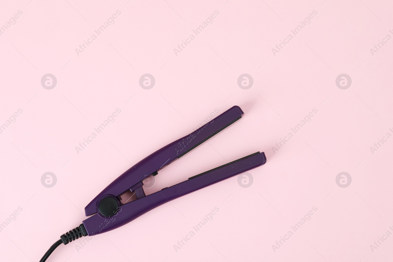 Photo of Modern hair iron for straightening on color background, top view