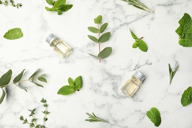 Photo of Flat lay composition with essential oil in bottles and different herbs on marble background