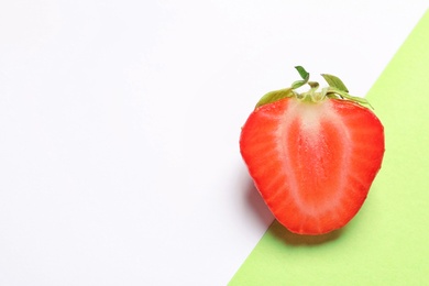 Half of ripe strawberry on color background, top view