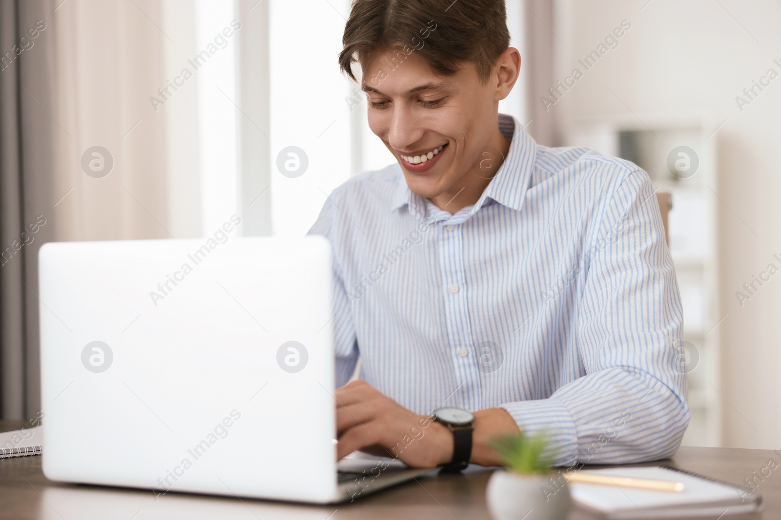 Photo of Man watching webinar at table in office