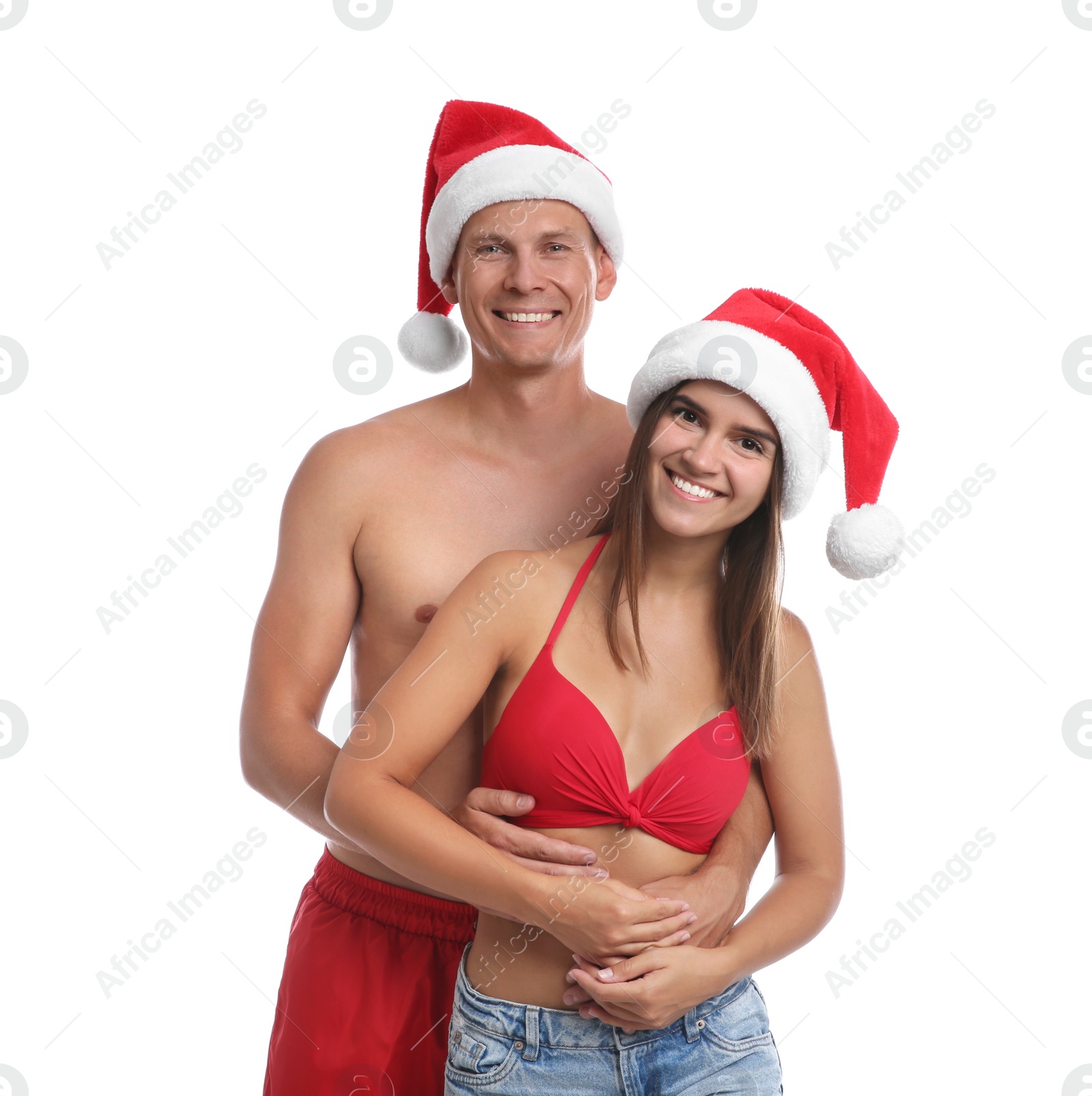 Photo of Happy couple with Santa hats together on white background. Christmas vacation