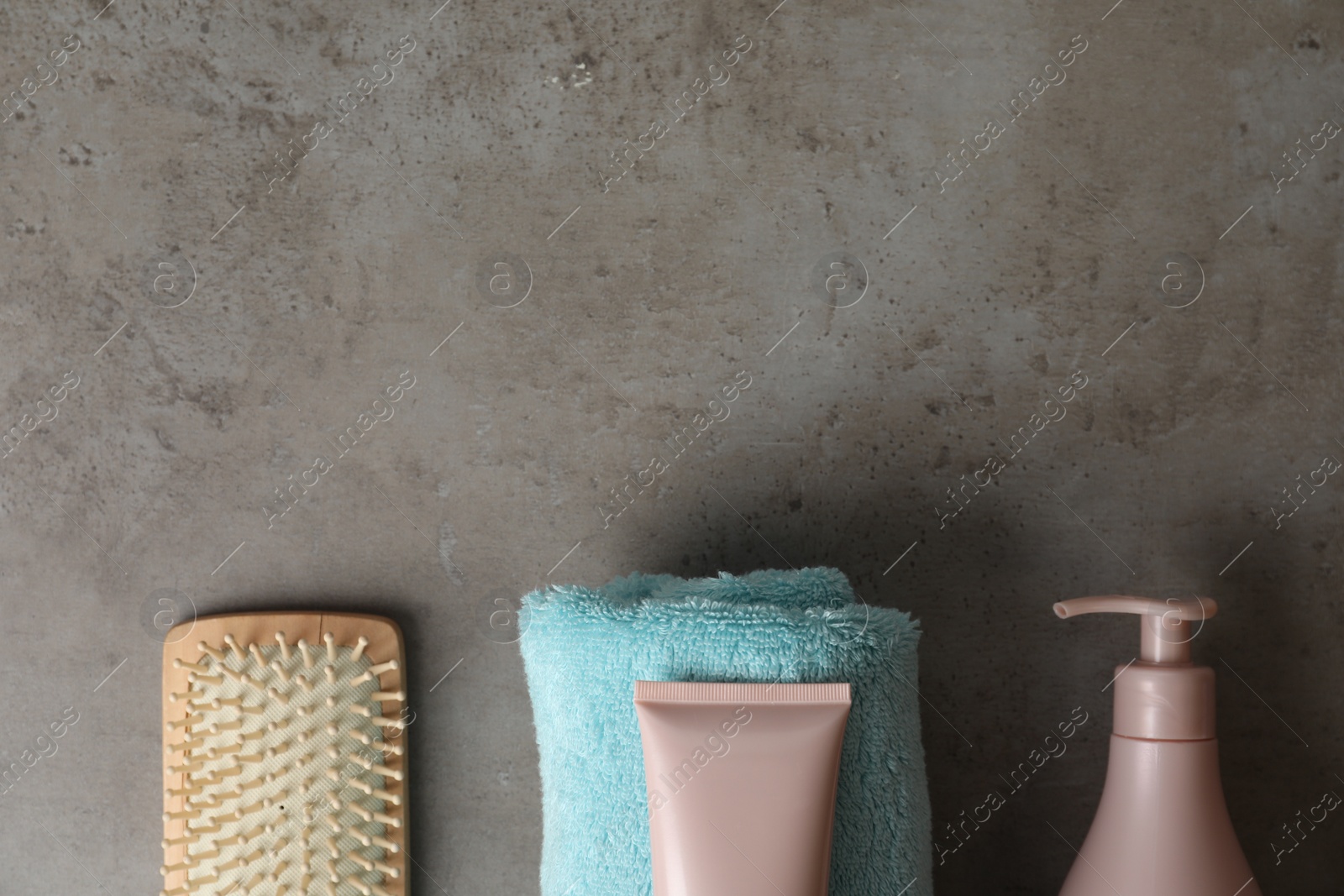 Photo of Different hair products, towel and brush on grey table, flat lay. Space for text