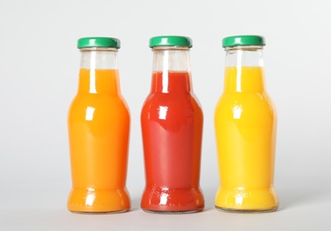 Bottles with different drinks on color background