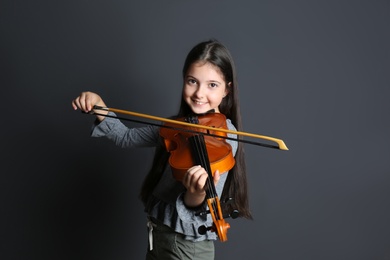 Photo of Preteen girl playing violin on black background