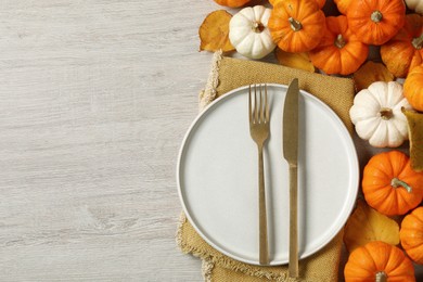 Photo of Happy Thanksgiving day. Beautiful table setting, autumn leaves and pumpkins on wooden background, flat lay with space for text