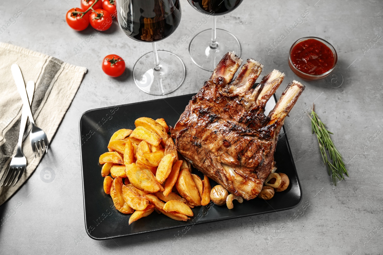 Photo of Delicious grilled ribs served on light grey table