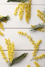 Beautiful mimosa flowers on white wooden table, flat lay