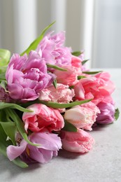 Beautiful bouquet of colorful tulip flowers on light gray table
