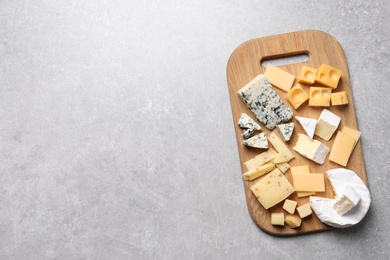 Photo of Cheese plate on light grey table, top view. Space for text