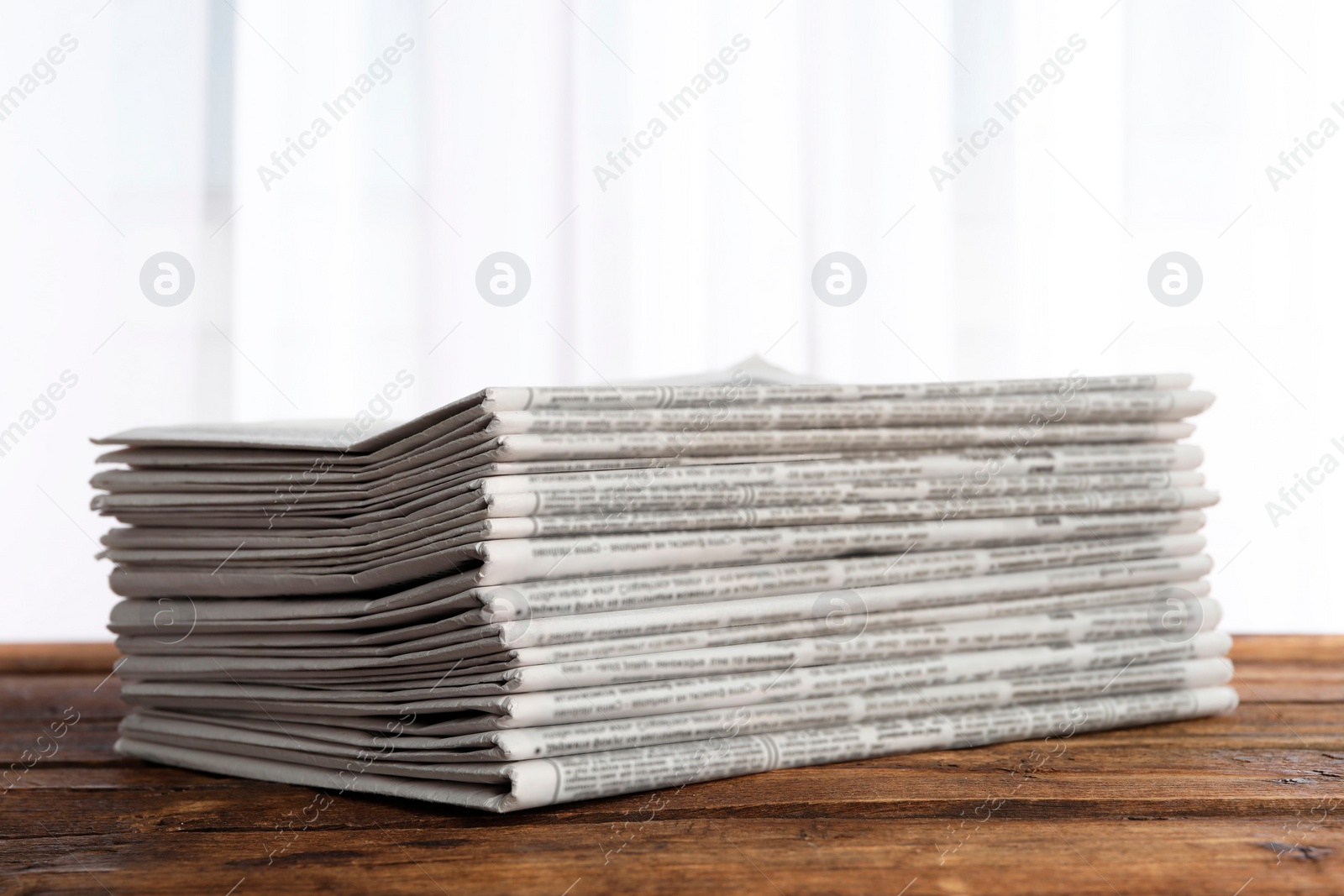 Photo of Stack of newspapers on wooden table. Journalist's work