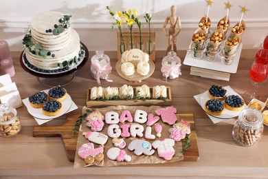 Photo of Baby shower party. Different delicious treats on wooden table indoors, above view